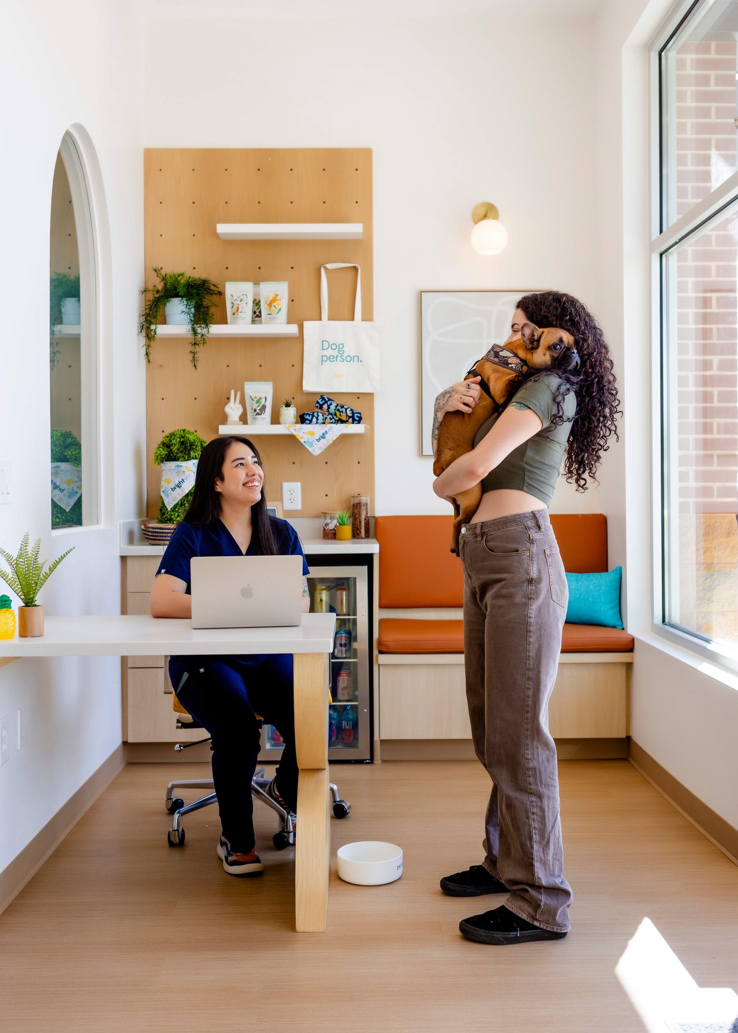woman holding a dog in a vet clinic