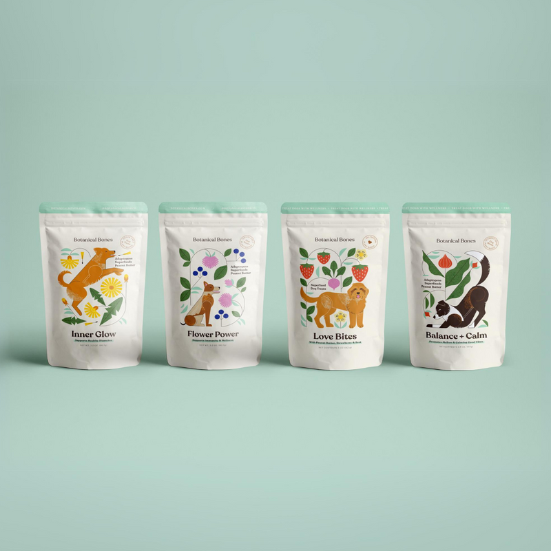 Four packages of botanical bones superfood dog treats, each with a different label and illustrations representing different themes such as 'Flower Power', 'Balance + Calm', 'Inner Glow', and 'Love Bites'.